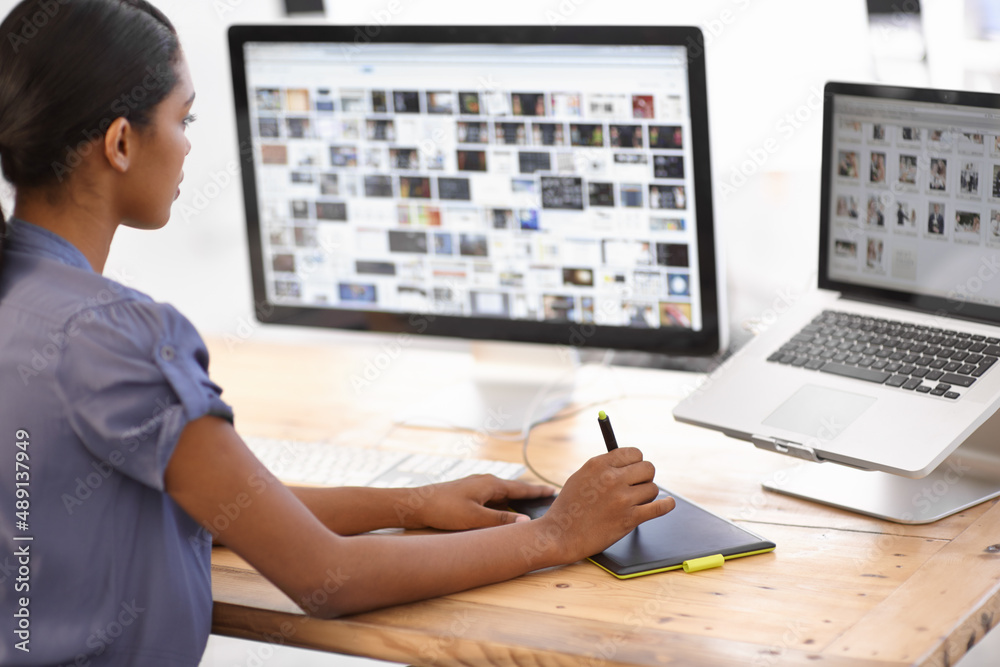 Using technology to get the job done. Cropped shot of an attractive young businesswoman using a wire