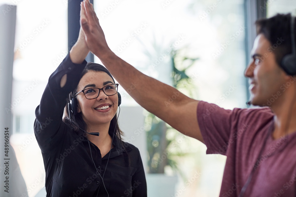 Always proving a quality customer service experience. Shot of two call centre agents giving each oth