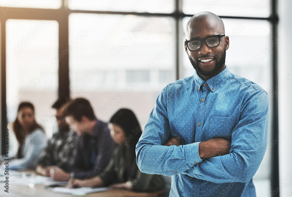 Were always ready to help you succeed. Portrait of a cheerful businessman posing with his arms folde