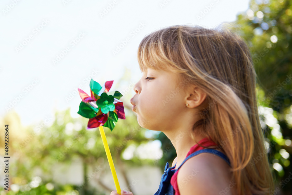 All i need to have fun.... Shot of a cute little girl playing with a pinwheel outside.