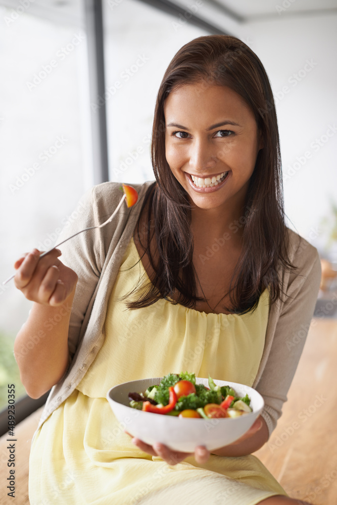 Enjoying a healthy snack. A lovely young woman enjoying a healthy salad.