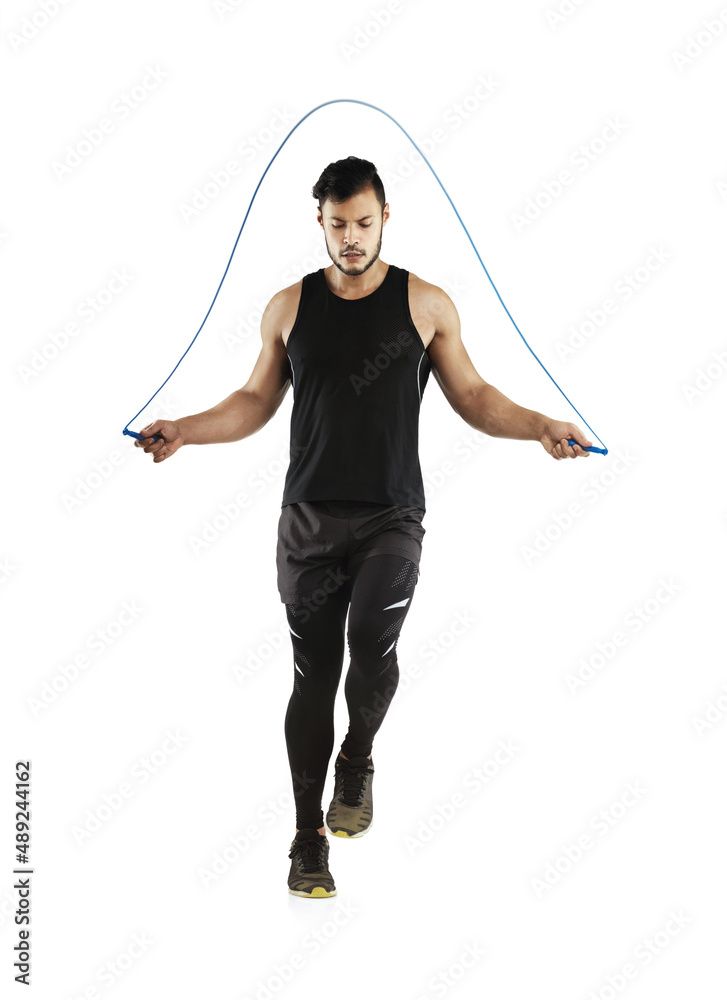 Getting his heart rate going. Studio shot of a young man skipping with a jump rope against a white b