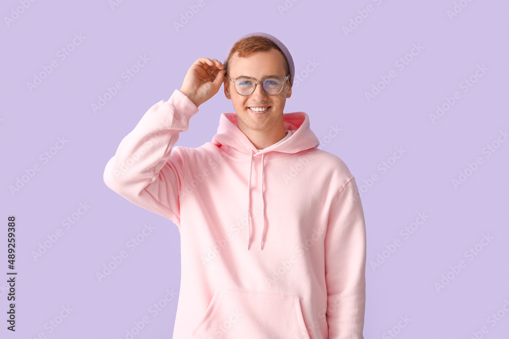 Young guy in stylish hoodie on color background