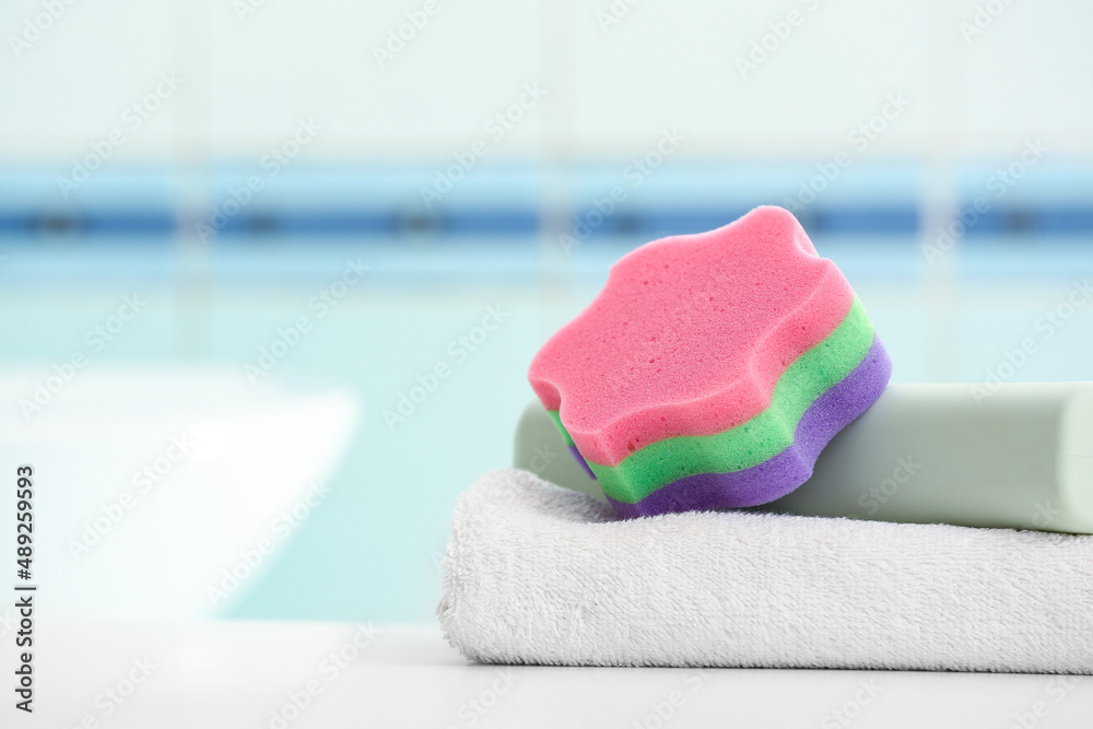 Clean towel and bath sponge on table