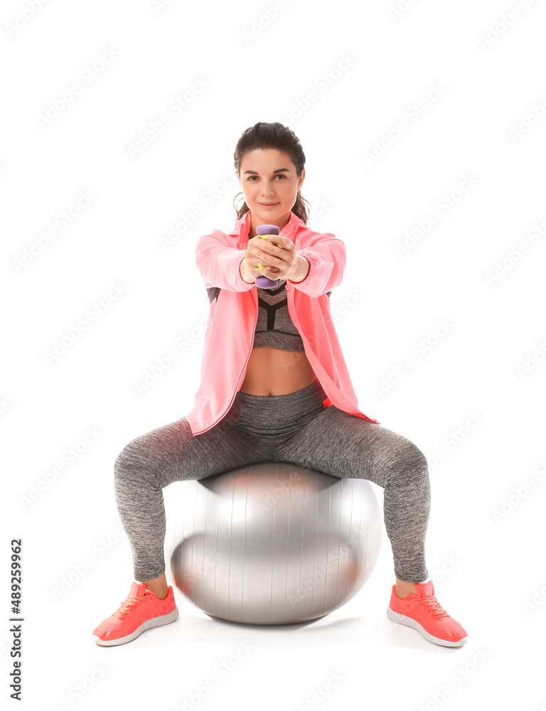 Young sporty woman training with fitball on white background