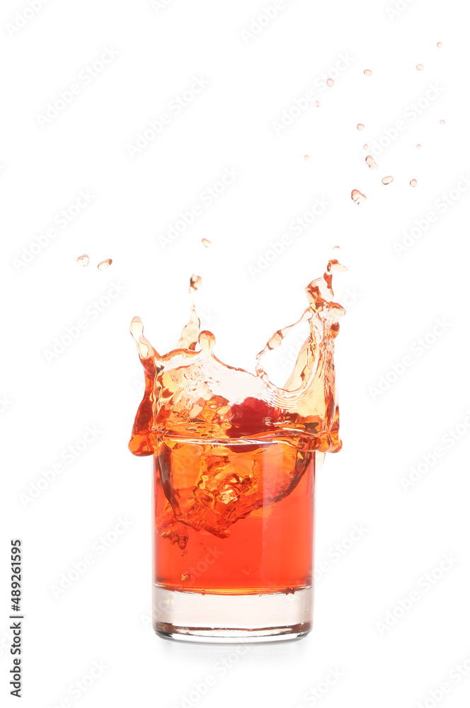 Glass of tasty Manhattan cocktail with splashes isolated on white background