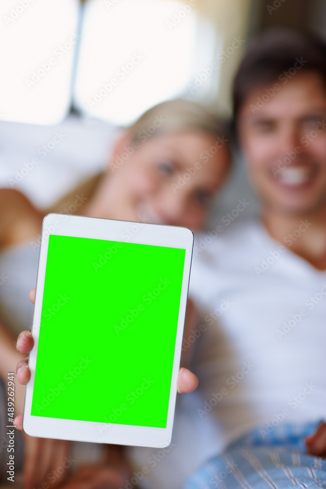 Make your homepage as happy as our home. Closeup shot of a happy couple lying in bed and holding up 