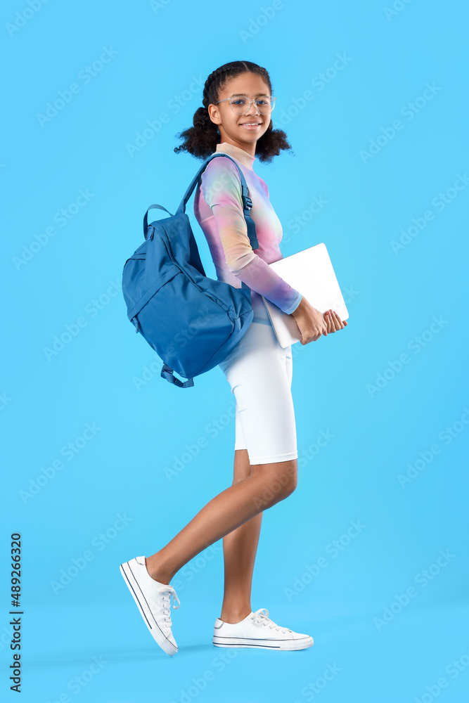 African-American female student with laptop on blue background