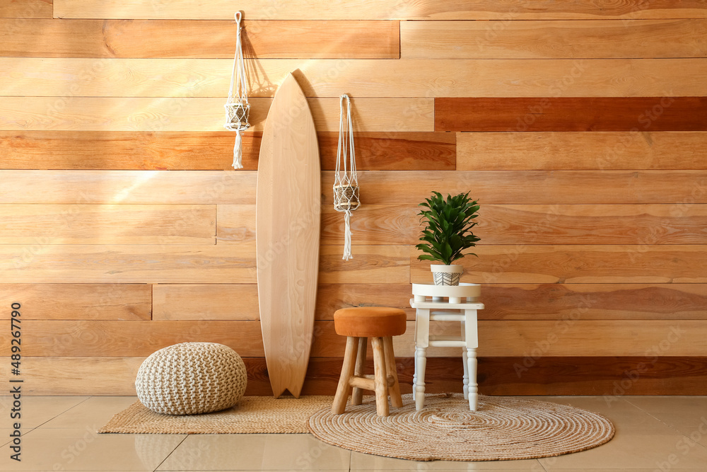 Interior of stylish room with wooden surfboard and houseplants