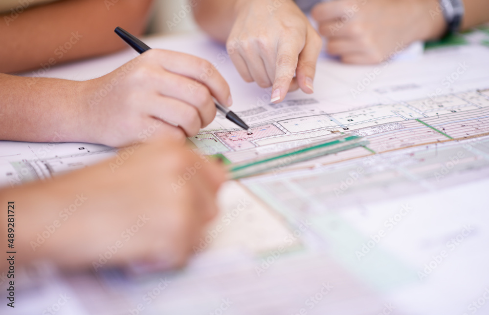 Making sure everything is correct. Cropped shot of a group of architects reviewing blueprints.