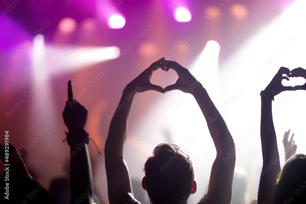 Showing some love for the band. Rearview of people in the audience at a music concert holding up the