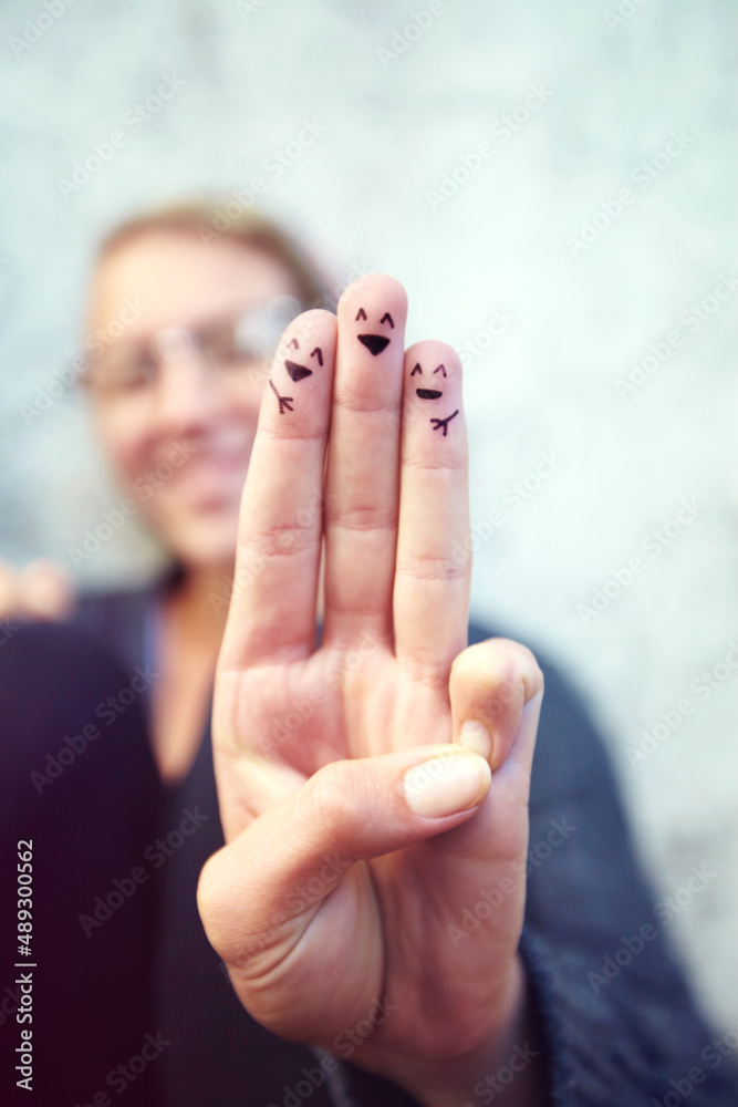 Happy happy. Cropped shot of fingers with smileys drawn on them.