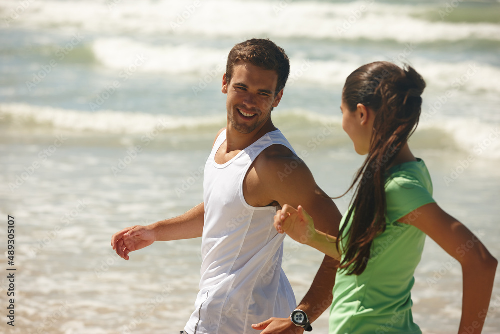 See you later. Shot of a young couple jogging together on the beach.