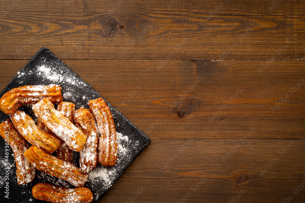 Churros with powdered sugar. Fat fast food sweets