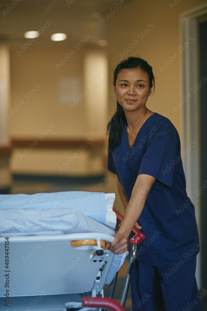 Getting the bed ready for the next patient. Cropped shot of a female nurse standing beside a hospita