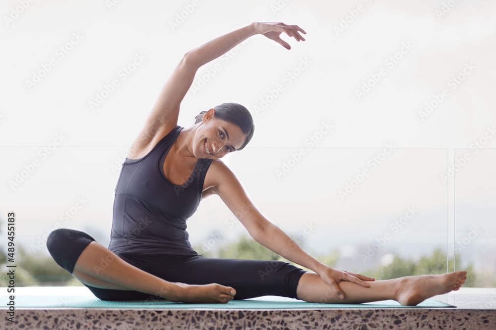 Yoga is a way of life. Portrait of a young woman doing yoga stretches on her patio.