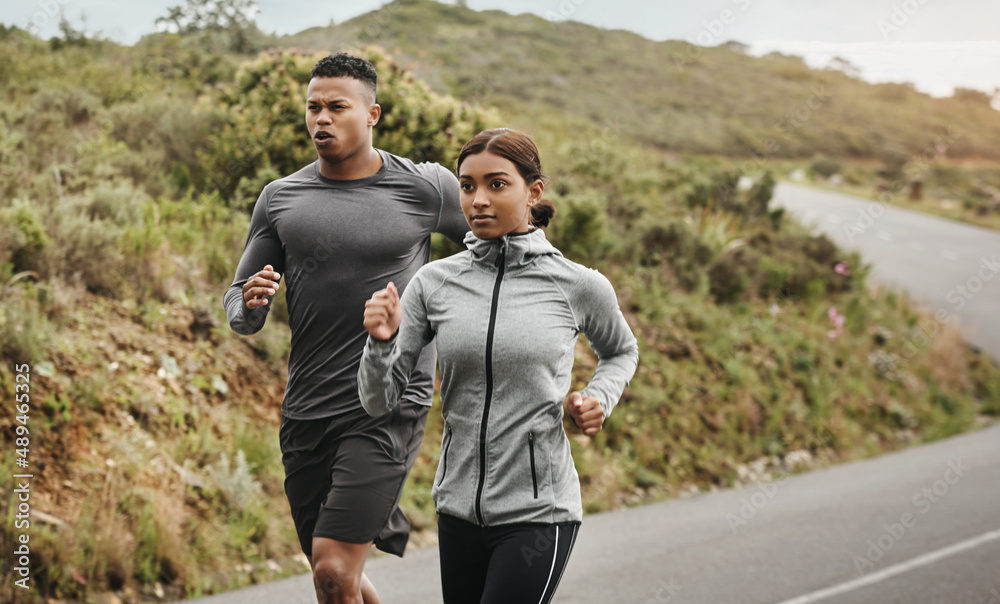 Dont stop until you reach the end. Shot of two sporty young people running outdoors.