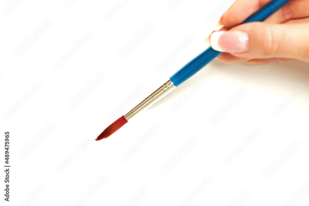 An artists delight. Close up shot of a female hand holding a paintbrush - white background.