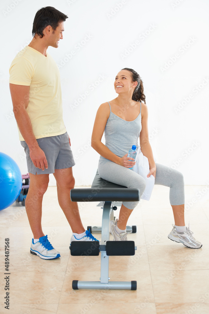 Ready to exercise. Two young people talking to each other at the gym.