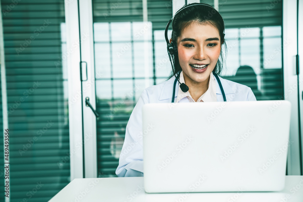 Doctor wearing headset talking actively on video call in hospital or clinic . Concept of telehealth 