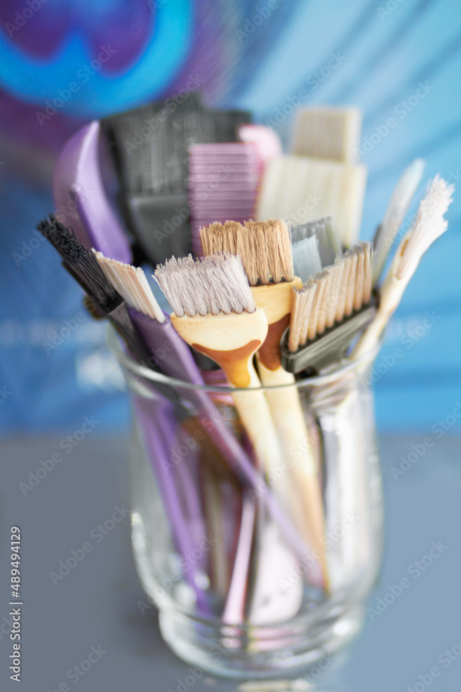 Let your hair be their canvas. A glass jar filled with hair colouring brushes.