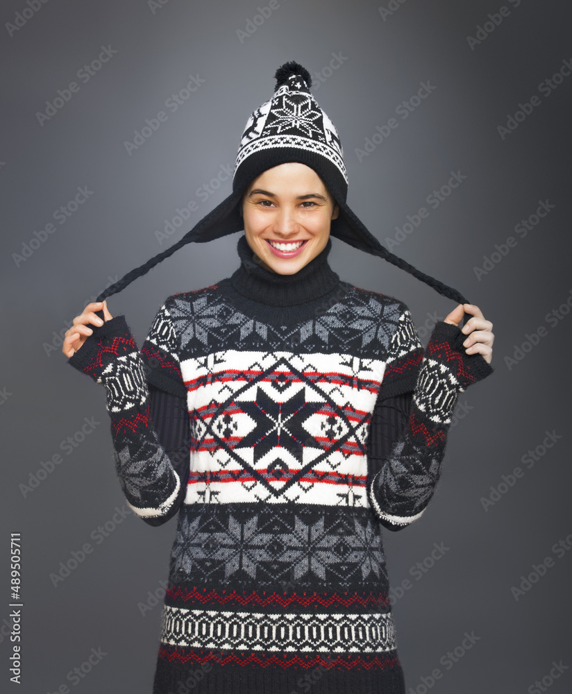 Smiling Girl with Funny Winter Hat. Studio portrait of a cute young woman dressed for winter.