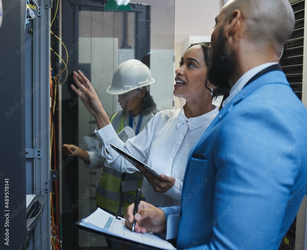 Run me through this again. Shot of two workers inspecting the electronic equipment in a server room 