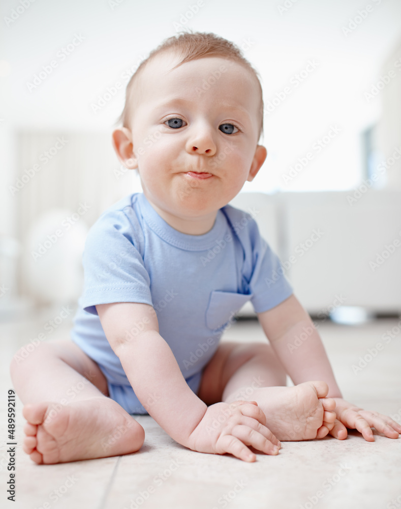 Exploring the living room. A baby boy sitting on the living room floor.