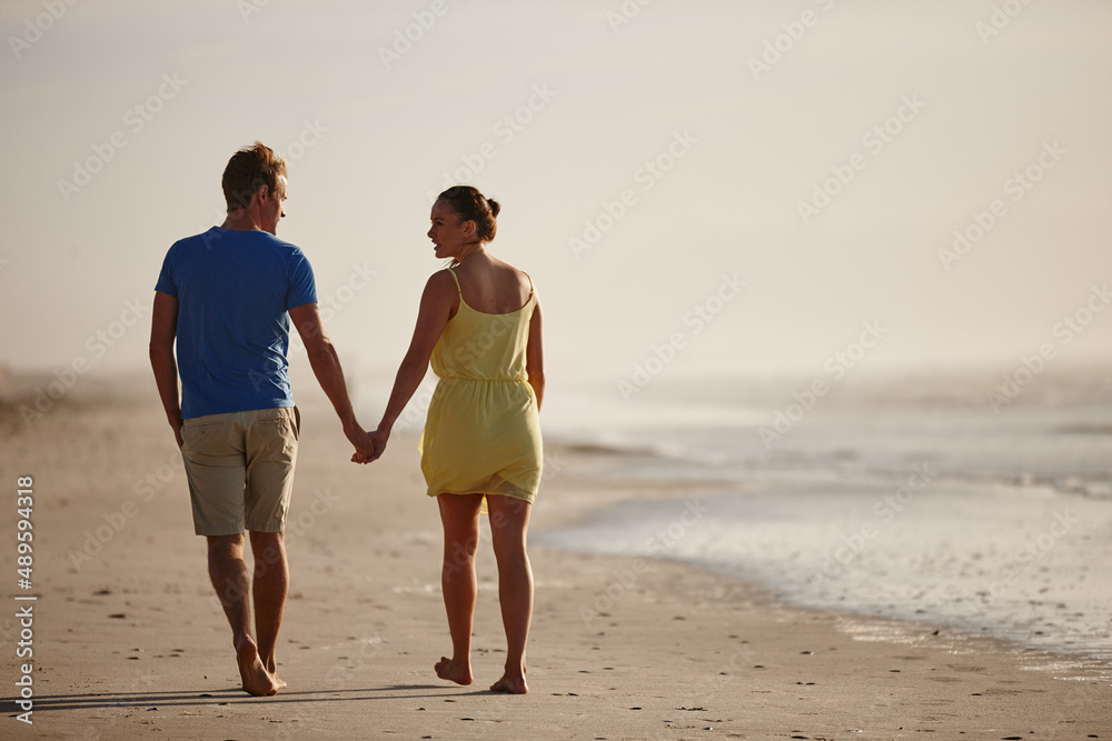 Hand in hand on the beach. Shot of an affectionate couple walking on the beach.