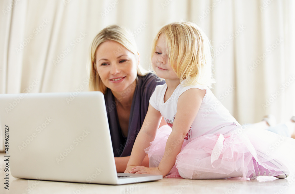 Shes pretty techno-savvy for such a young kid. Shot of a mother and daughter bonding while surfing t