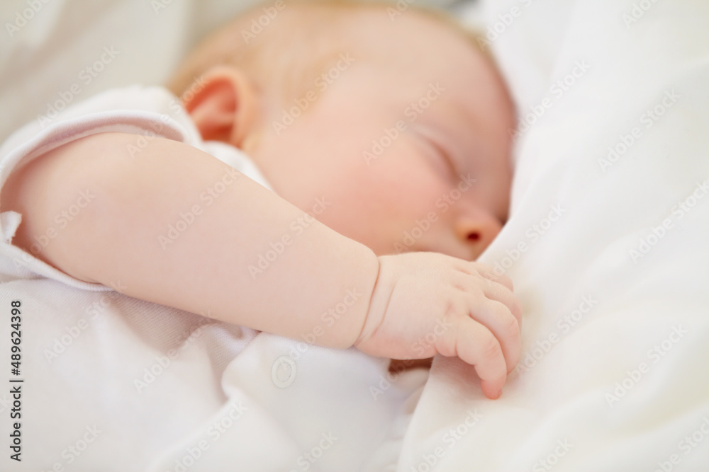 Baby in dreamland. A baby girl fast asleep in between her white pillows.