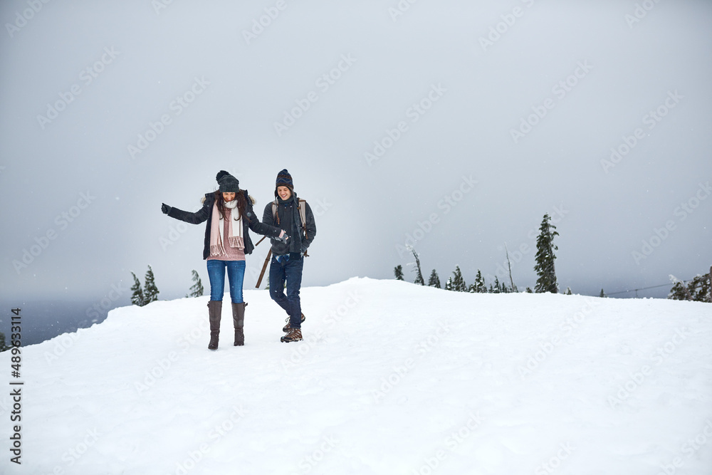 我们喜欢在雪地里。一对幸福的年轻夫妇在雪地里享受的照片