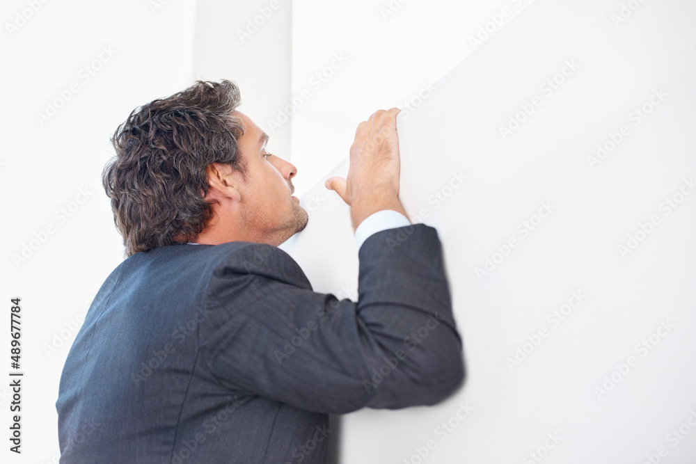 Man peeking over wall. Smart business man peeking over the wall.