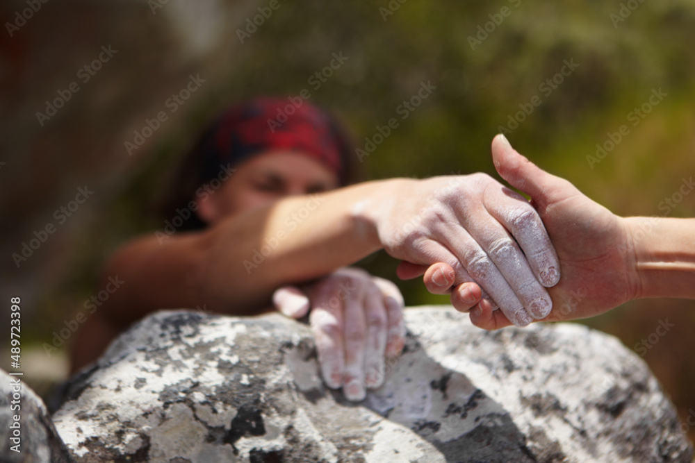 A helping hand. One rock climber giving a helping hand to another.