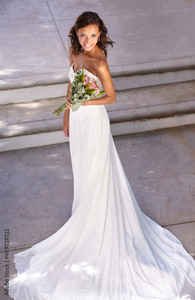 Shes a beautiful bride. Beautiful young bride holding her bouquet.