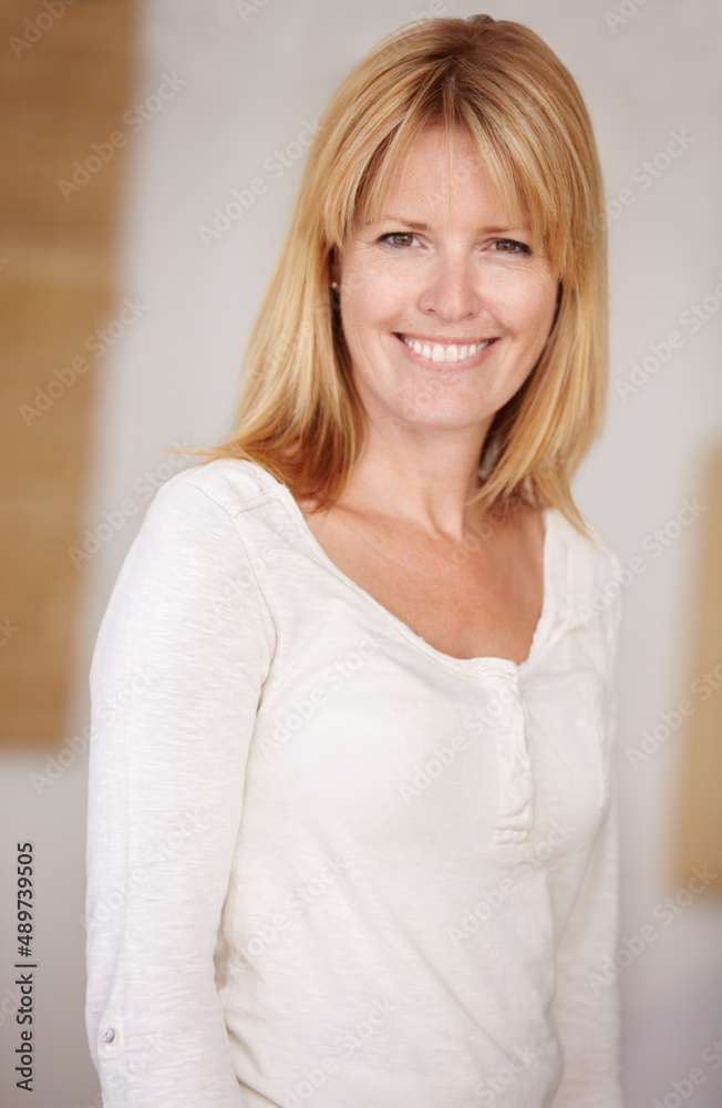 She radiates confidence. A beautiful mature woman smiling at the camera.