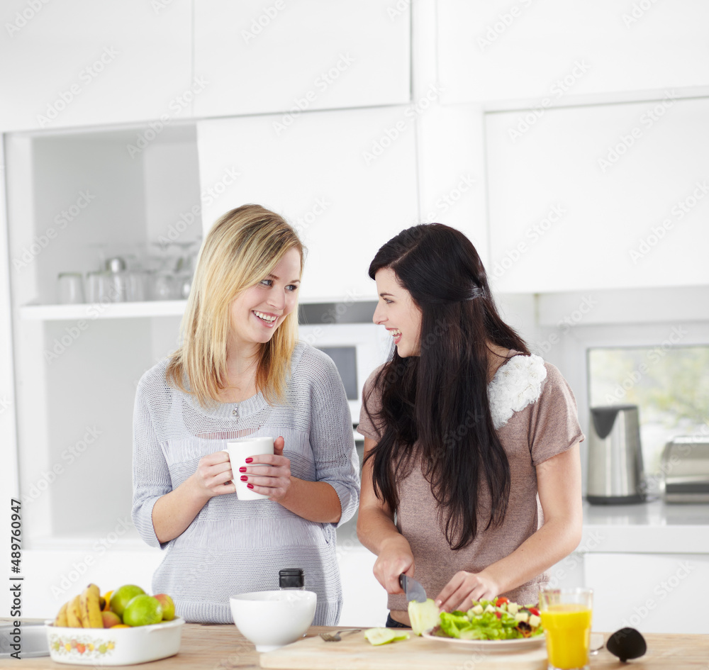 以健康的方式为女孩做午餐。两位年轻女性在家里的厨房里做沙拉。