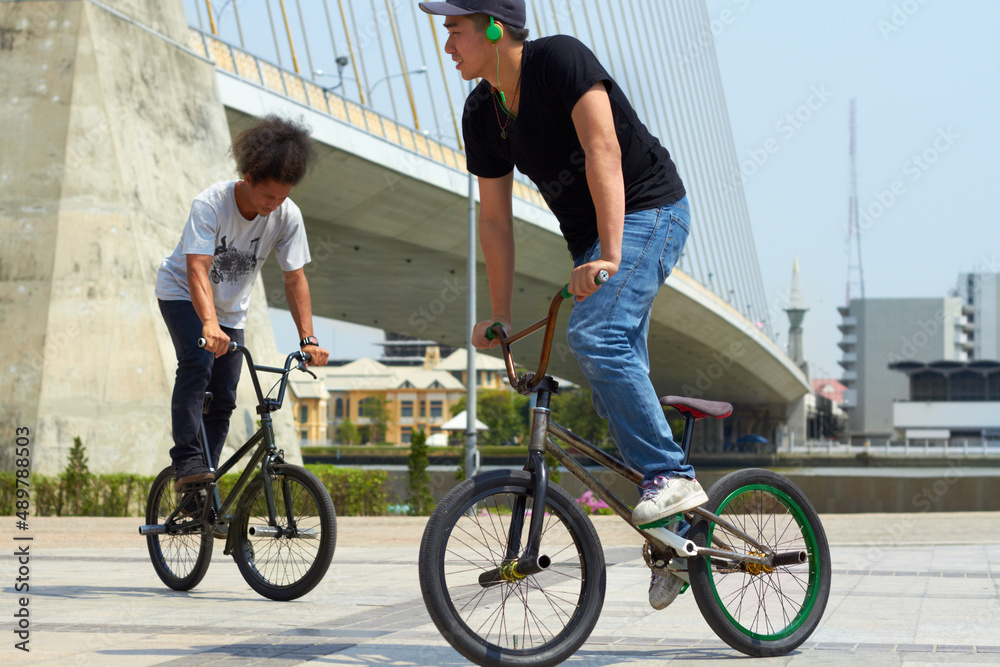 轮流展示他们的东西。BMX骑手在城市里玩把戏。