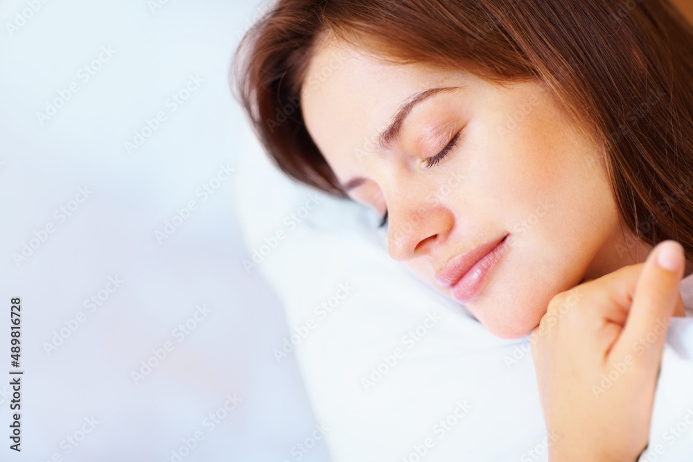 Closeup of a pretty female fast asleep in bed. Closeup portrait of a cute young female fast asleep i