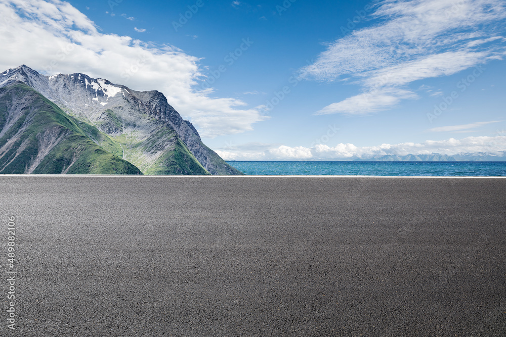 Asphalt road and mountain with lake natural scenery under blue sky