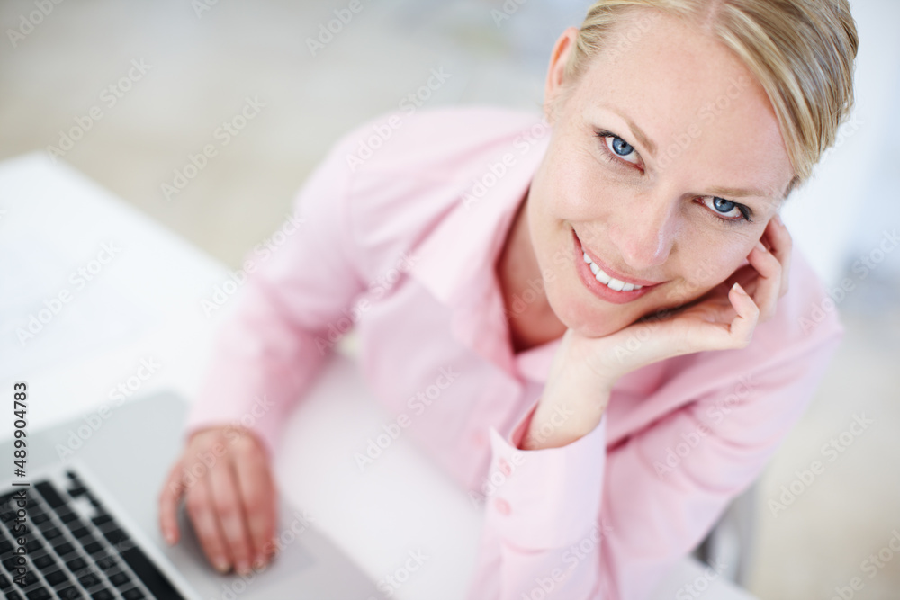 All set to run her new business from home. Portrait of a young blond woman sitting at her desk with 