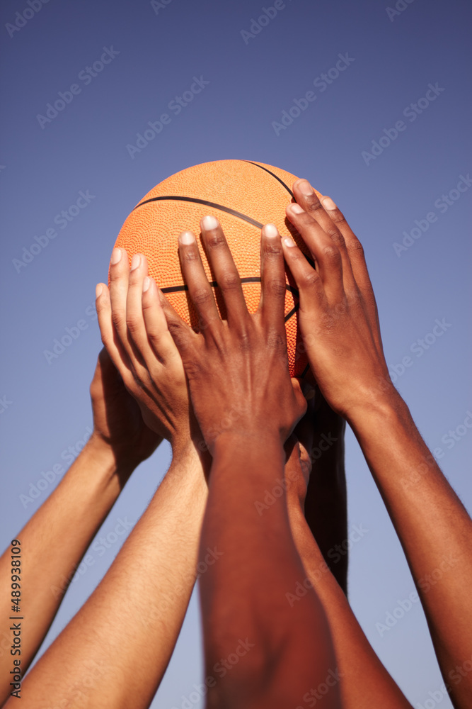 Man united. Closeup of hands holding up a basketball.