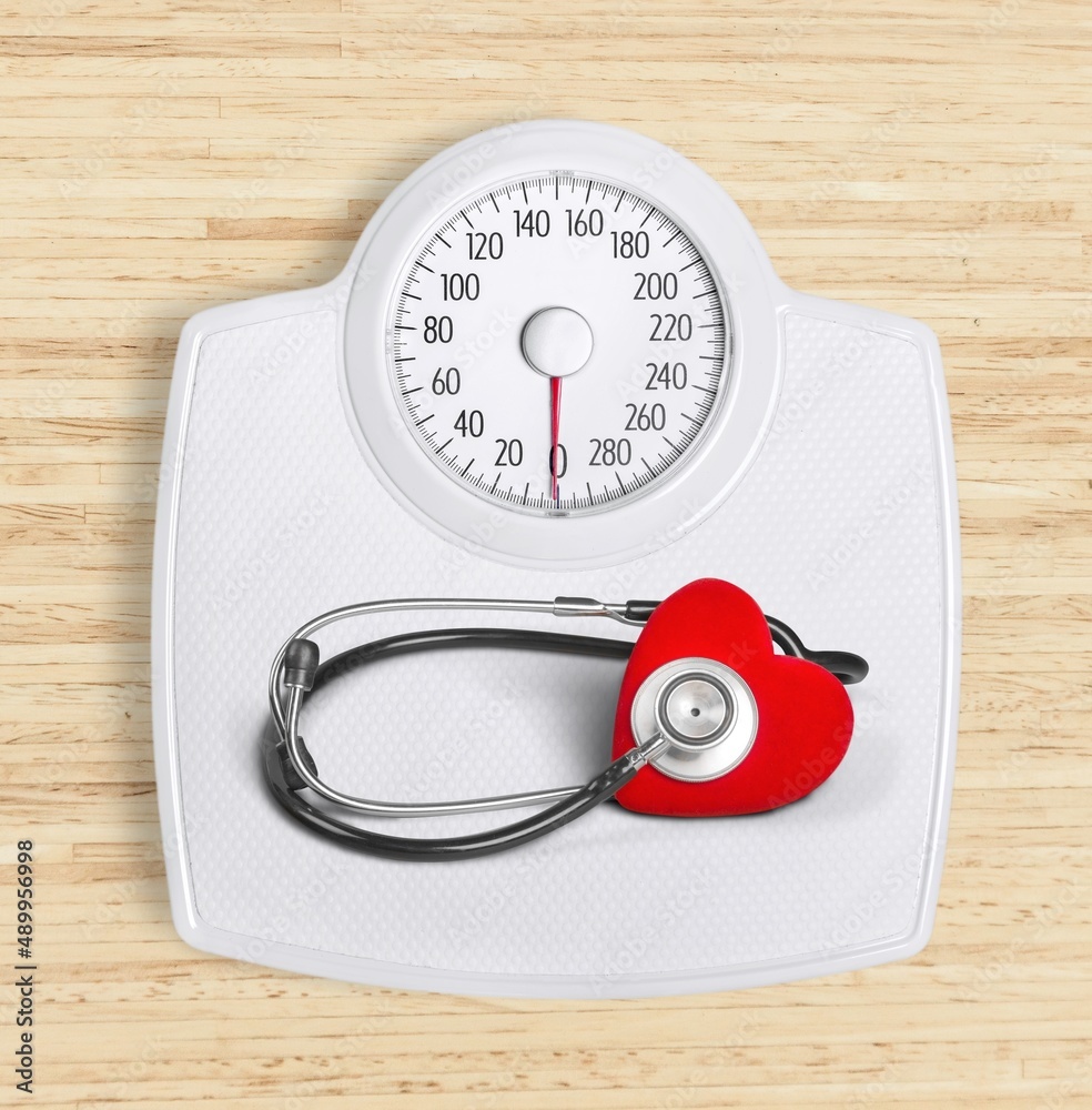 Weight scale with stethoscope, concept of correlation between weight and heart conditions