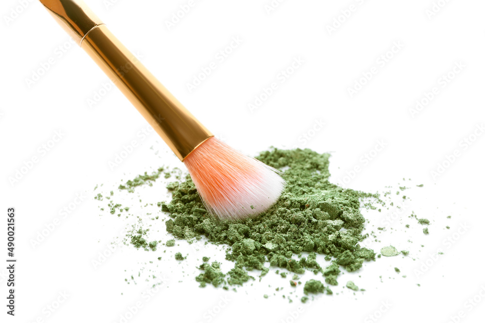 Makeup brush and loose eye shadow on white background