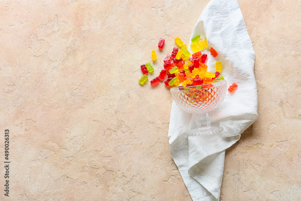 Dessert bowl with sweet jelly bears on light background