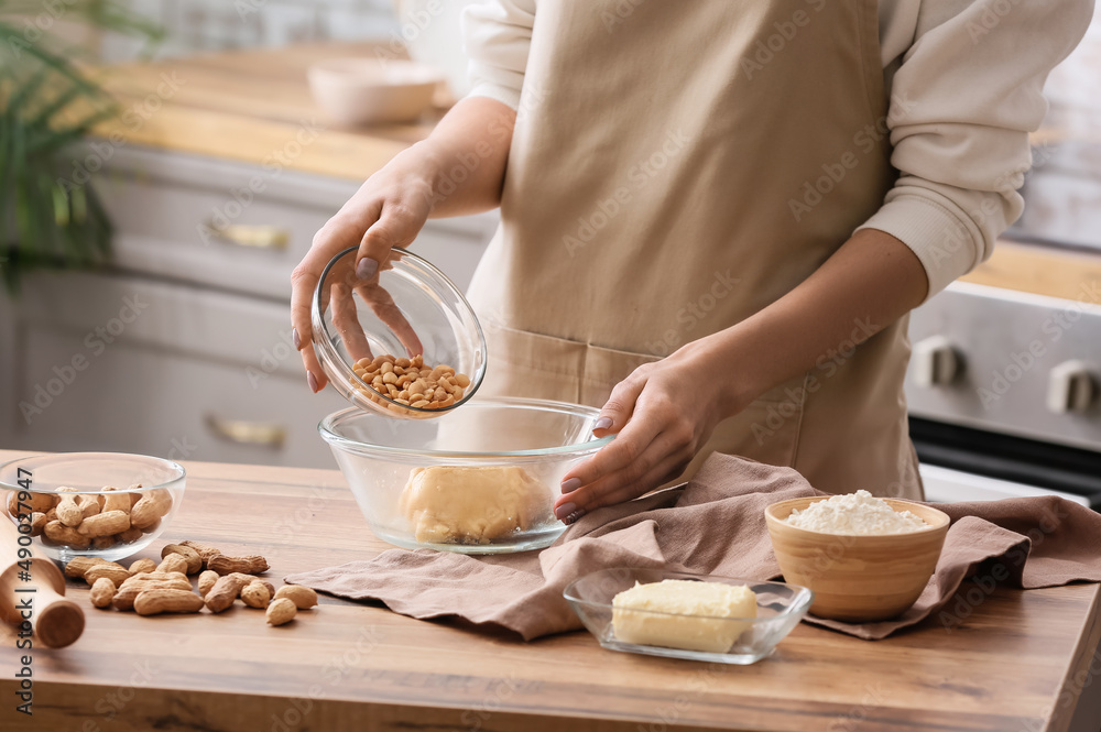 Woman preparing peanut cookies at kitchen table, closeup