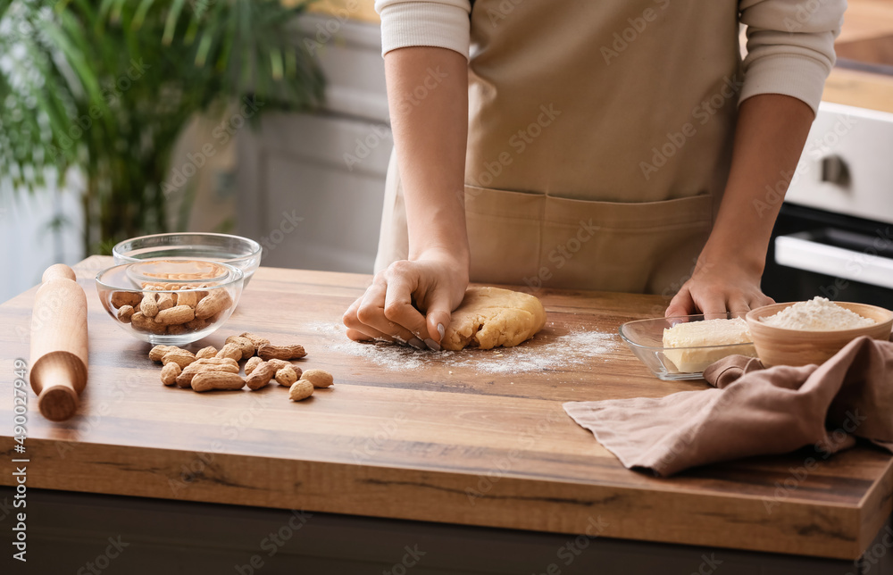 Woman preparing peanut cookies at kitchen table, closeup