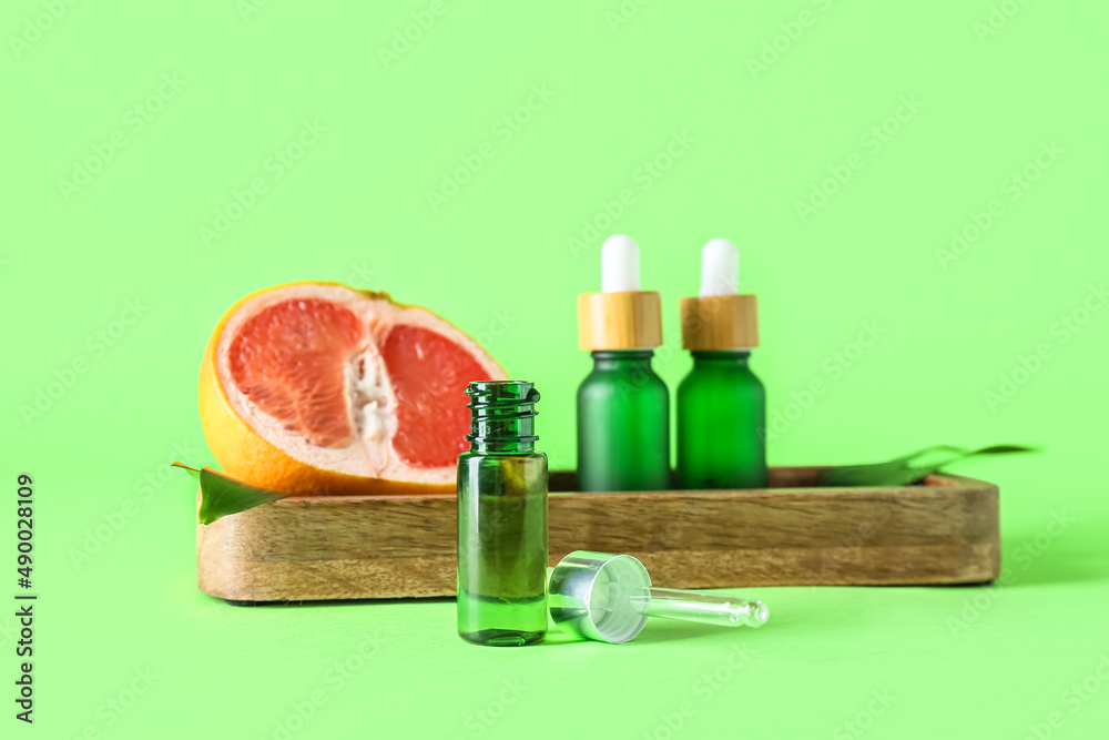 Bottle of essential oil on green background