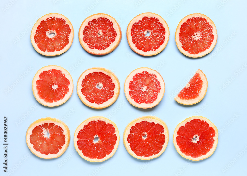 Slices of tasty ripe grapefruit on blue background