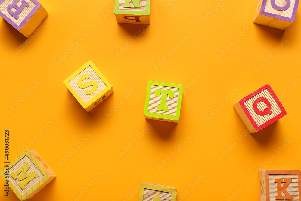 Wooden cubes with letters on color background